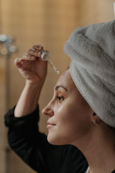 women applying face serum